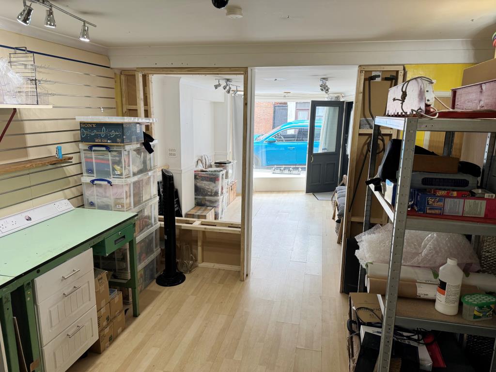 Lot: 69 - SHOP AND TWO-BEDROOM FLAT FOR INVESTMENT OR OWNER OCCUPATION - Ground floor commercial unit looking towards road